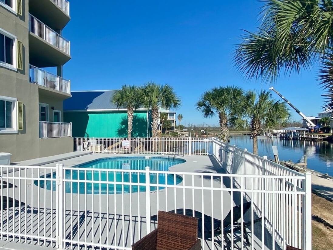 Photo of a white aluminum fence around a pool on a riverfront property